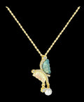 Butterfly-shaped pendant with gemstones on a gold chain against a white background